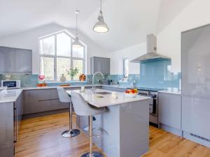 a kitchen with white counters and blue cabinets at 4 Bed in Combe Martin 82500 in Trentishoe