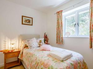 a bedroom with a bed with a window and a table at 4 Bed in Combe Martin 82500 in Trentishoe
