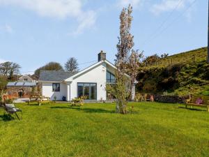 a white house with a tree in the yard at 4 Bed in Combe Martin 82500 in Trentishoe