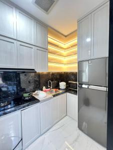 雅加達的住宿－Belle's WMR Guest House，厨房配有白色橱柜和不锈钢冰箱