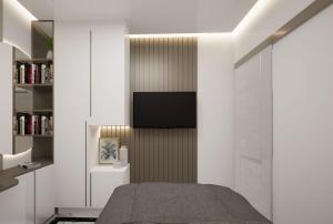 a bedroom with a bed and a tv on a wall at Belle's WMR Guest House in Jakarta