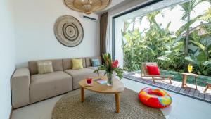 Premier Umalas Villas في كيروبوكان: غرفة معيشة مع أريكة وطاولة