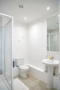 a white bathroom with a toilet and a sink at Serviced Apartment In Liverpool City Centre - Free Parking - Balcony - by Happy Days in Liverpool