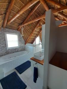 a bathroom with a tub and a sink at Zeezicht Villa - Jacobsbaai in Jacobs Bay