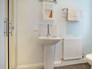a bathroom with a white toilet and a sink at 2 Bed in Lulworth 94448 in Winfrith Newburgh