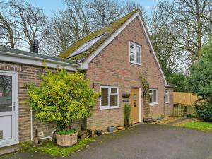 a brick house with a tree in a driveway at 2 Bed in Lulworth 94448 in Winfrith Newburgh