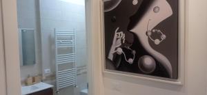 ターラントにあるGli Amici della Pugliaの洗面台とトイレ付きのバスルームの絵画