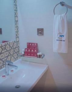 a bathroom with a white sink and a towel at Pearl Inn Hotel in Karachi