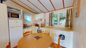- une cuisine avec une table en bois dans l'établissement Mobil Home 40 avec piscines, à Brem-sur-Mer