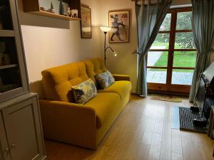 a living room with a yellow couch and a window at El Niuet in Pla de l'Ermita