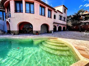 a house with a swimming pool in front of a building at Villa Bonaventura in Calonge