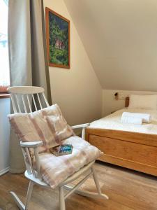 uma cadeira de baloiço branca num quarto com uma cama em Guest house Ivica i Marica in heart of the national park Plitvička jezera em Plitvica selo