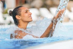 Una mujer en el agua en una piscina en Best Western Plus Kurhotel an der Obermaintherme, en Bad Staffelstein