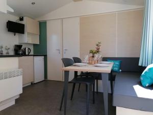 a small kitchen with a table and chairs in a room at Comfortable chalet with microwave on a holiday park 1 km from the beach in Koudekerke