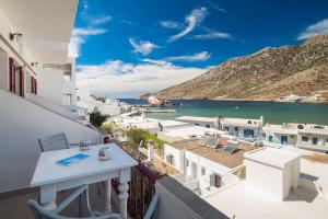 a balcony with a view of the ocean and buildings at Simeon Rooms & Apartments in Kamares