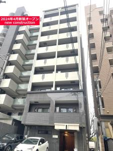a building with a car parked in front of it at COCOSTAY銀山町リバーサイド,COCOSTAY Kanayamacho riverside, Great location river view-5 min walk from the nearest station in Hiroshima