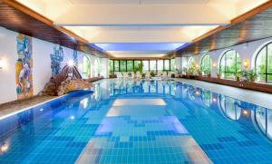a large swimming pool with blue tiles in a building at Haus Tiroler Heimat in Nauders