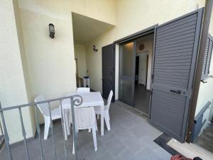 a patio with a table and chairs on a balcony at Casa Porto San Rocco in Marina di Grosseto