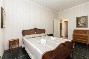 a bedroom with a large bed and a dresser at IMMOBIRENT - 5min spiagge - 15min centro città in Genoa
