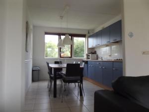 a kitchen and dining room with a table and chairs at Semi detached house in Franeker with a shared pool in Franeker