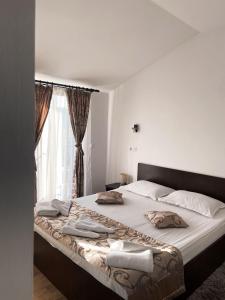 - une chambre avec un grand lit et une fenêtre dans l'établissement Pensiunea Antonio, à Pietrari