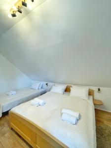 two beds in a room with white sheets at Guest house Ivica i Marica in heart of the national park Plitvička jezera in Plitvica selo