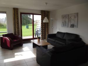 a living room with a couch and chairs and a table at Semi detached house in Franeker with a shared pool in Franeker