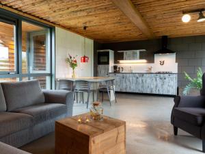 ein Wohnzimmer mit einem Sofa und einem Tisch in der Unterkunft Bungalow with decorative fireplace on farm in Heeten
