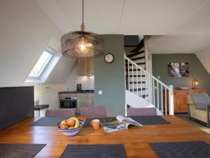 een keuken en eetkamer met een tafel met een fruitschaal bij Holiday Home with garden near Mookerplas in Plasmolen