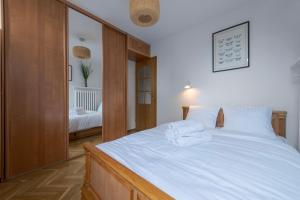 - une chambre avec un grand lit et des draps blancs dans l'établissement RentPlanet - Apartament Mirów, à Varsovie