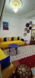 ein Wohnzimmer mit einem gelben Sofa und einem Tisch in der Unterkunft Dar Rif Kebdani in Tangier
