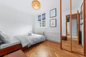 - une chambre avec un lit et un miroir dans l'établissement RentPlanet - Apartament Mirów, à Varsovie