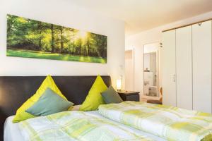 ein Schlafzimmer mit einem Bett mit gelben und grünen Kissen in der Unterkunft Bauzinger Alm in Hauzenberg