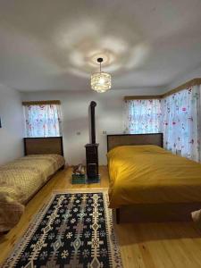a bedroom with two beds and a rug at Florija’s Guesthouse in Dardhë