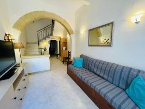 sala de estar con sofá y TV en Beach House - Seaview Holiday Home en Marsalforn