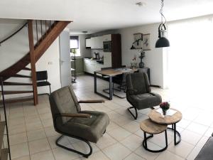 a living room with chairs and a table and a kitchen at Nice house with large garden in Noordwijk and near the sea in Noordwijk aan Zee