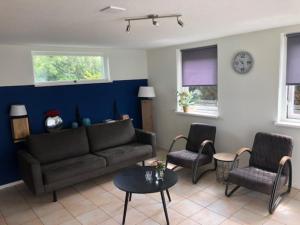 a living room with a couch and two chairs at Nice house with large garden in Noordwijk and near the sea in Noordwijk aan Zee