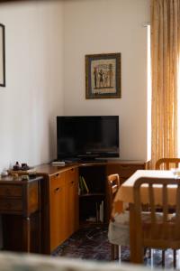 salon z telewizorem z płaskim ekranem i stołem w obiekcie Residenza Maria Pia w Turynie
