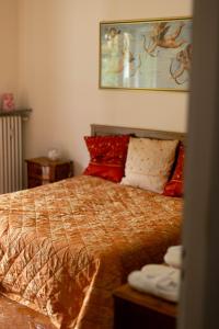 sypialnia z łóżkiem z czerwonymi poduszkami w obiekcie Residenza Maria Pia w Turynie