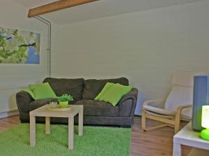 a living room with a couch and a table at Tidy chalet with a microwave in the Achterhoek in Ootmarsum