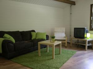 a living room with a couch and a table at Tidy chalet with a microwave in the Achterhoek in Ootmarsum