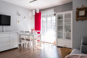 una cucina e una sala da pranzo con tavolo e tenda rossa di Apartament Eliza w centrum APARTZAKOP a Zakopane