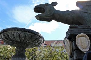 een standbeeld van een fontein met een paard dat spuugt bij Hotel Palais Porcia in Klagenfurt