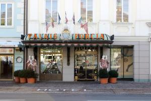 a store on a street with plants in front of it at Hotel Palais Porcia in Klagenfurt