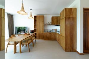 a kitchen with wooden cabinets and a wooden table at Premier Umalas Villas in Seminyak +47 photos