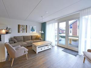 UitgeestにあるLake View apartment with dishwasher close to Amsterdamのリビングルーム(ソファ、テーブル付)
