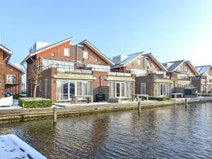 una fila di case vicino a un corpo d'acqua di Lake View apartment with dishwasher close to Amsterdam a Uitgeest