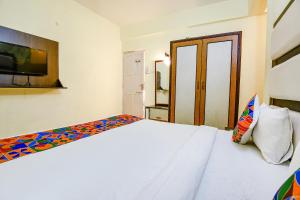 a bedroom with a bed and a tv on the wall at FabExpress Jesant Valley Resort in Candolim