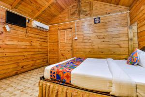 a bedroom with a bed in a wooden cabin at Via Jesant Valley Resort - Nr Candolim Beach in Candolim +23 photos