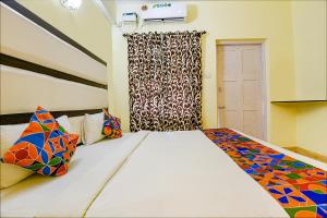 Un dormitorio con una cama grande con almohadas de colores. en FabExpress Jesant Valley Resort, en Candolim